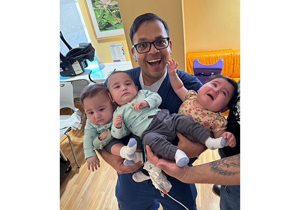 Dr. Parikh holding the Hernandez triplets at CHRISTUS Children's