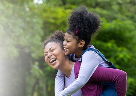Mother with daughter on her back