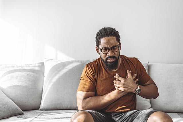 African American man holding his chest in pain